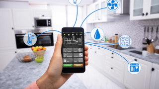 Woman's Hand Using Home Control System On Cellphone With Various Icons In The Kitchen
